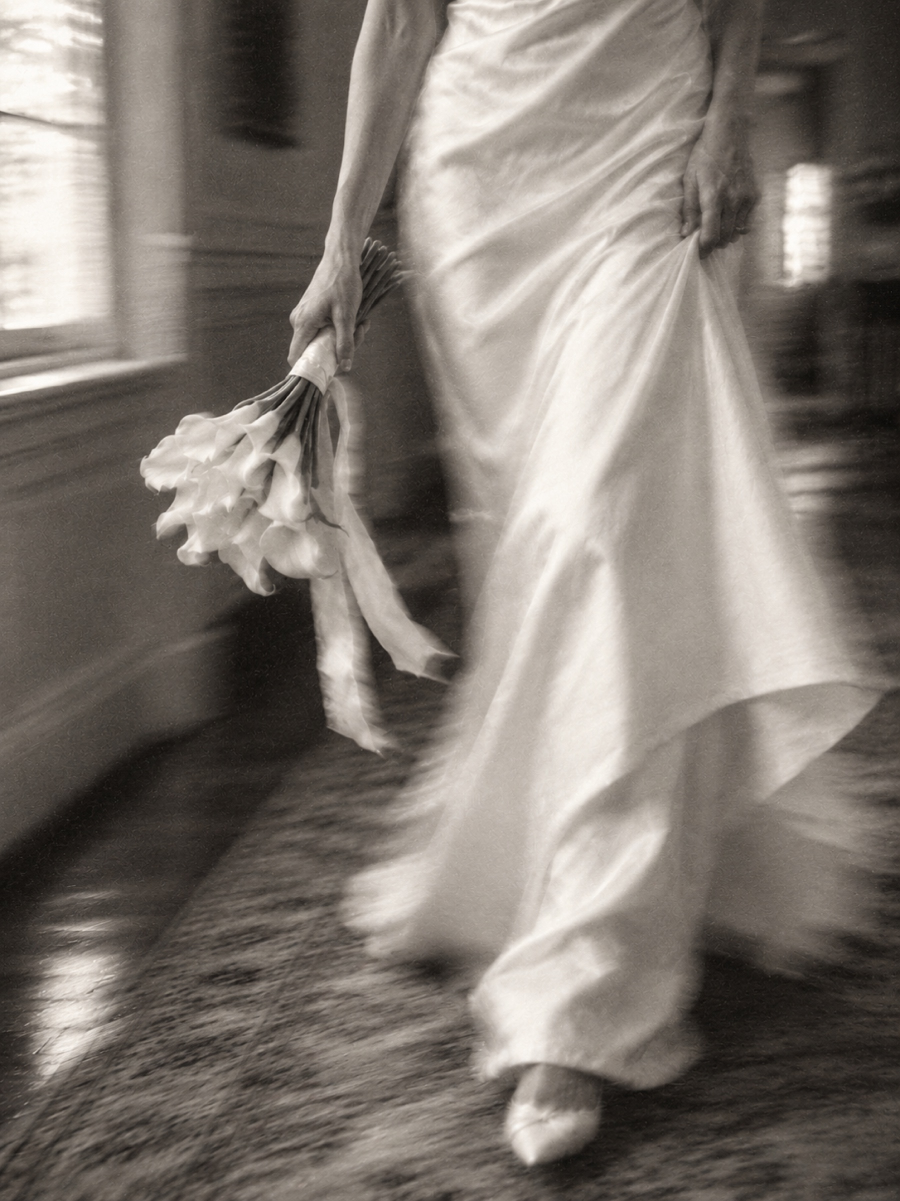 Bride carrying white calla lilies