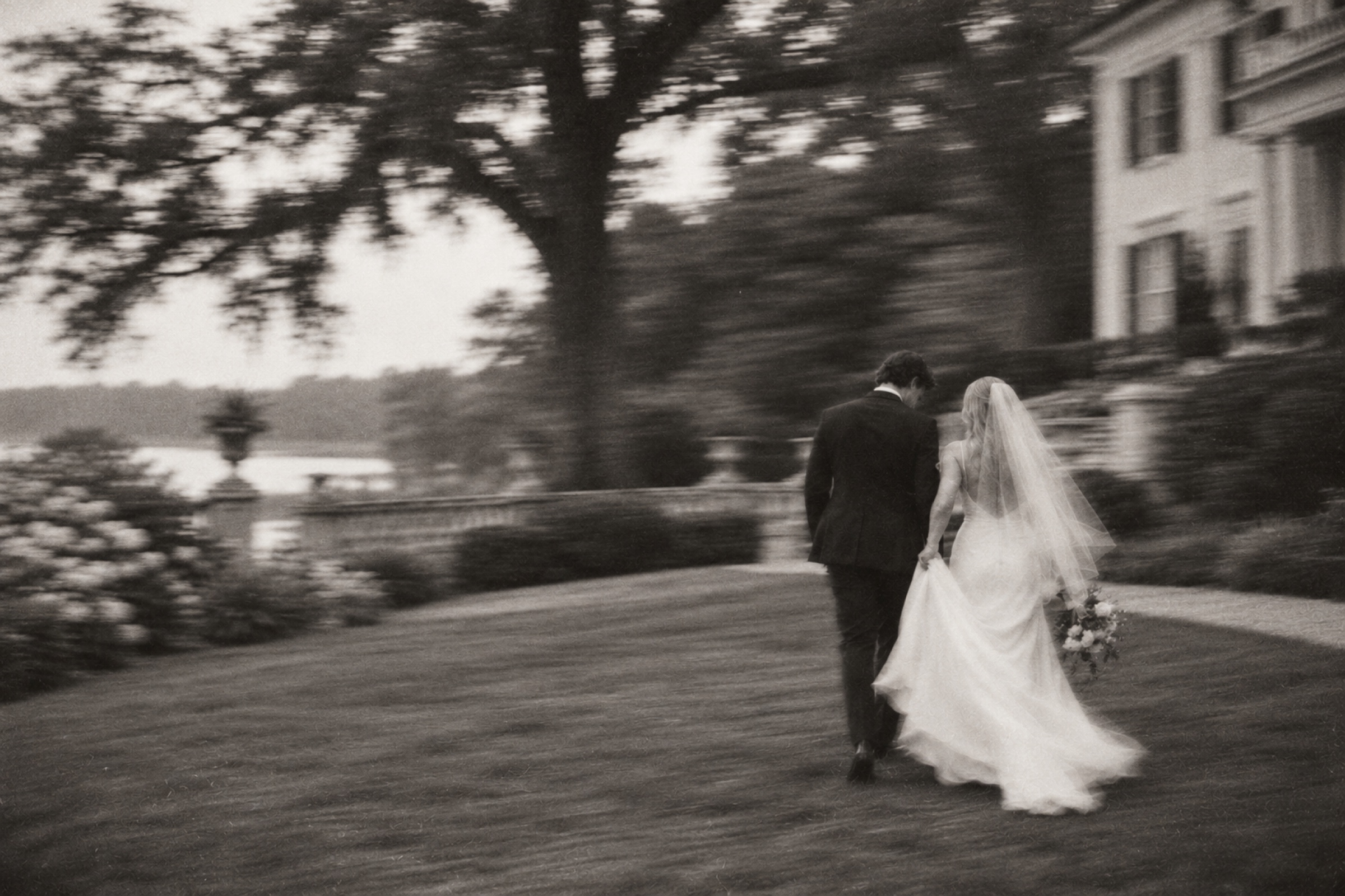 Newlyweds walking through a Southern estate garden